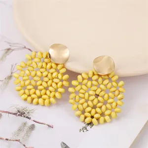 Handmade yellow wooden bead woven drop earrings, boho geometric retro jewelry detail.