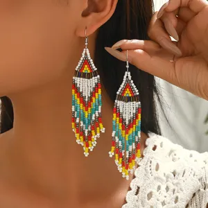 Close-up of bohemian geometric seed bead fringe earrings, handmade colorful drop earrings.