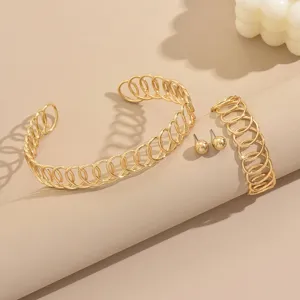 Detailed view of European style geometric winding metal bracelet and earring jewelry set.