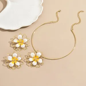 Gold-tone floral jewelry set featuring a rigid collar necklace and matching enamel flower earrings.