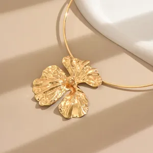 Close-up view of a chic gold metal irregular flower pendant choker necklace detail.