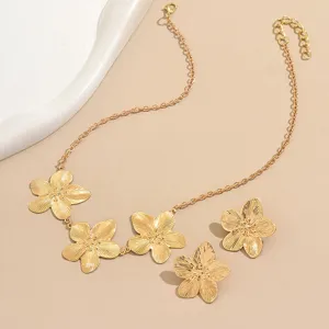 Detaillierte Nahaufnahme des stilvollen goldenen Blumen Metall Halskette und Ohrringe Set.