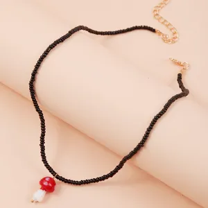 Details of the sweet beaded ceramic mushroom necklace with black seed beads and a cute pendant.