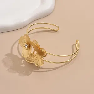 Bracciale da braccio aperto dorato con design floreale a farfalla e dettaglio in strass.