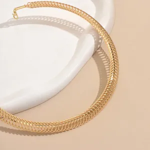 Gros plan du collier ras du cou en spirale dorée avec texture métallique et belle finition.