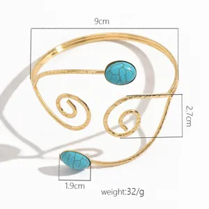 Primo piano del bracciale da braccio aperto dorato con pietra turchese e design a spirale.