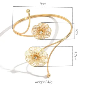 Bracciale da braccio aperto dorato con fiori geometrici traforati, gioiello elegante.