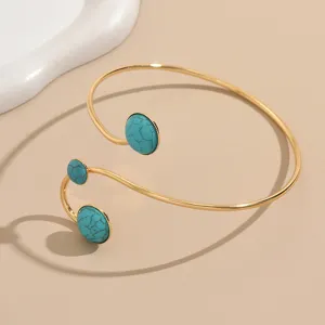 Vue détaillée d'un bracelet de bras ouvert tendance orné de pierres turquoises.