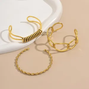 Set di 3 bracciali rigidi aperti dorati con design intrecciato, a maglia e a molla.