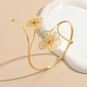 Dettaglio del bracciale da braccio dorato con raffinati motivi floreali traforati