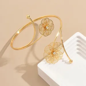 Elegante bracciale da braccio dorato aperto con design floreale geometrico e cristalli.