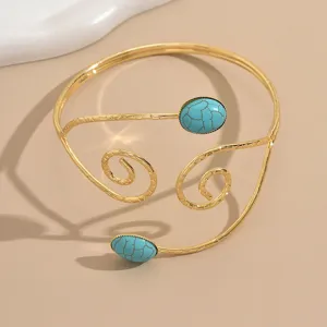 Elegante bracciale da braccio aperto geometrico dorato da donna con pietre turchesi trendy.