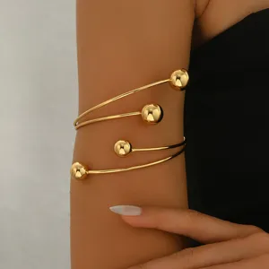 Bracciale da braccio a spirale dorato con sfere, gioiello da corpo alla moda ed elegante.