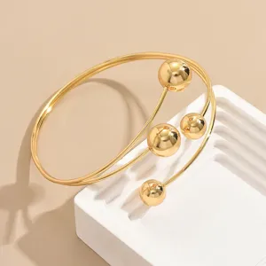 Elegante bracciale rigido dorato multi strato con sfera geometrica dettaglio moda.