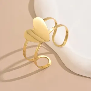 Detailed close-up of the stylish gold open cuff bracelet featuring a large hollow heart design.