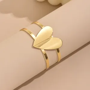 Gold open cuff bracelet featuring a bold geometric hollow heart design, modern minimalist style.
