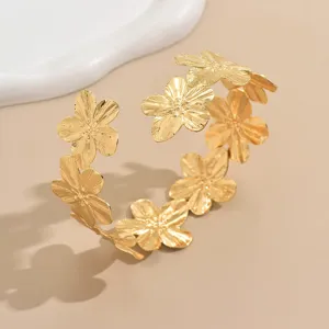 Vista dettagliata del bracciale rigido floreale dorato, gioiello da braccio aperto a strati.