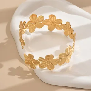 Primo piano dettagliato del brillante bracciale dorato con motivi floreali in metallo.