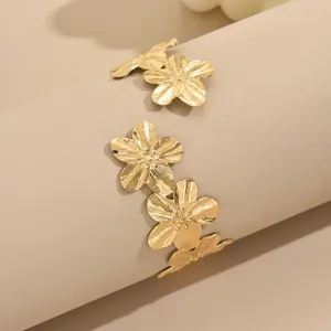 Bracciale rigido aperto con fiori dorati, elegante gioiello da braccio in metallo per donne.