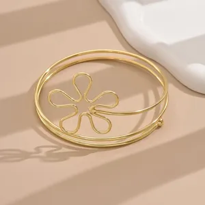 Primo piano dettagliato di un bracciale da braccio in filo metallico dorato stile geometrico.