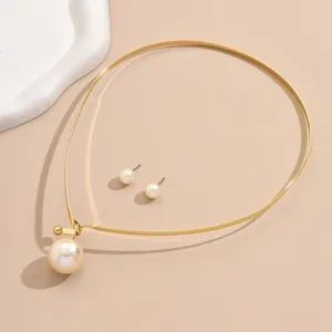 Detail view of gold-tone metal rigid choker necklace and pearl stud earrings set.