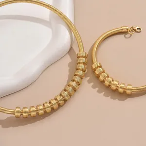Gold spring coil choker and bracelet jewelry set detail view, stylish metal wrap design.