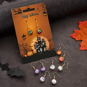 Λεπτομερές κοντινό πλάνο σετ σκουλαρικιών Halloween με χαριτωμένες κολοκύθες και πολύχρωμες χάντρες.