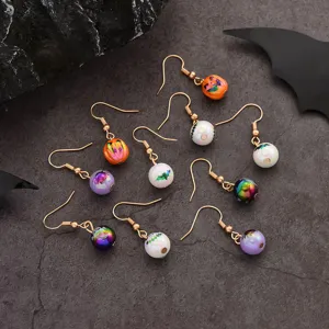 Λεπτομέρειες των σκουλαρκίων Halloween με χαριτωμένες κολοκύθες και νυχτερίδες σε φόντο.