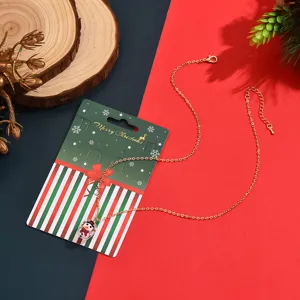 Detailaufnahme einer goldenen Halskette mit Glas-Kapsel-Schneemann-Anhänger als Weihnachtsgeschenk.
