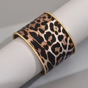 Wide leopard print cuff bracelet with sleek gold-tone metal edges, stylish accessory for modern women.