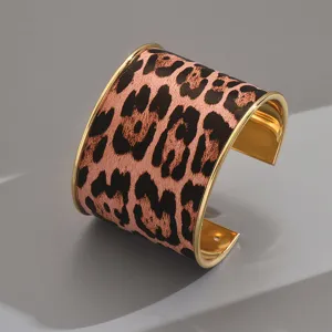 Leopard print wide cuff bracelet, geometric open design with golden metal trim for women.