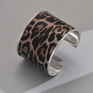 Detailed shot of a wide leopard print cuff bracelet with sleek metal trim for women.