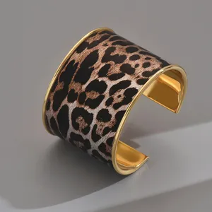 Wide leopard print cuff bracelet for women, stylish geometric open gold-rimmed wrist jewelry.