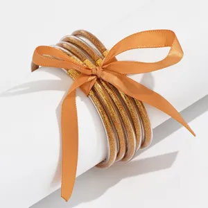Transparante meerlaagse glitter armbanden detailweergave met stijlvolle strik.