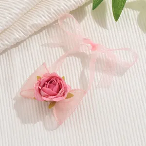 Primo piano dettaglio del bracciale rosa in pizzo, elegante design con nastro floreale donna.