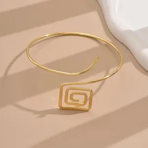 Dettaglio di un bracciale da braccio geometrico quadrato color oro elegante e moderno.