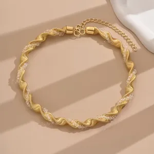 Gold spiral crystal choker necklace detail shot, elegant geometric fashion neck jewelry accessory.