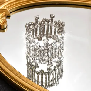 Close-up of wide sparkling crystal stretch cuff bracelet detail, shining rhinestones on mirror surface.