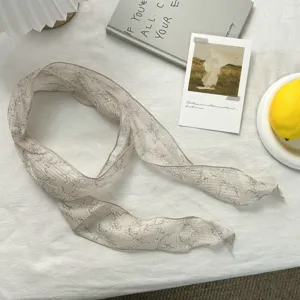 Detalle de pañuelo de seda estrecho con estampado floral, elegante accesorio para cuello.