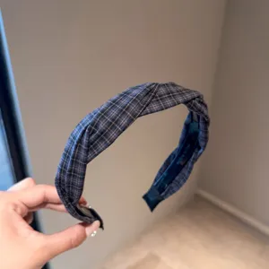 Retro karierter Knoten Haarreif Detailansicht mit Stoffstruktur für elegante Damenfrisuren.
