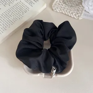Klassieke zwarte stoffen haarscrunchie, zacht en veelzijdig haaraccessoire voor dagelijks.
