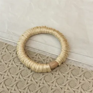 Detailansicht des eleganten, beigen Satin-Plissee-Haargummis mit glattem Harzverbinder.