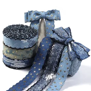 Nahaufnahme von Jeans-Paillettenbändern mit goldenen Sternen und Schleifen für DIY-Bastelarbeiten.