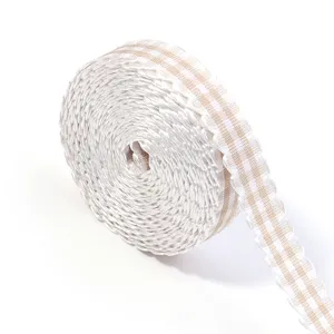 Gros plan d'un rouleau de ruban écossais beige et blanc avec bord ondulé double face.
