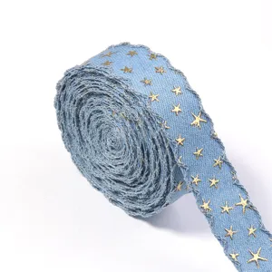 Detailaufnahme von blauem Jeansband mit Goldfoliensternen und welligem Glitzer.