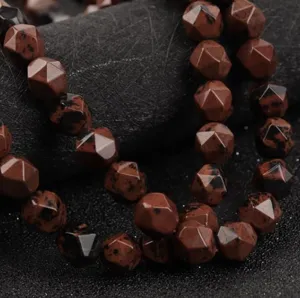 Primo piano di perline in pietra naturale sfaccettata, agata rossa, accessori per gioielli.