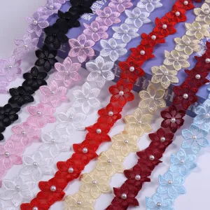 Detailed close-up of colorful embroidered lace trim with pearl beads for DIY crafts and sewing.