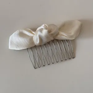 Satin Schleife Haarkamm Detail in Cremeweiß mit Metallzähnen, ideal für das tägliche Styling.