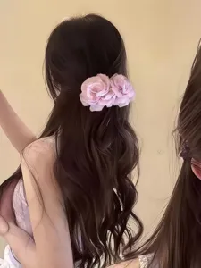 Detailaufnahme des süßen rosafarbenen Tüllblumen-Haarkamms für elegante Frühlingsfrisuren.