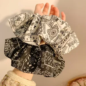 Detailed view of Korean style black and white paisley print fabric hair scrunchie.